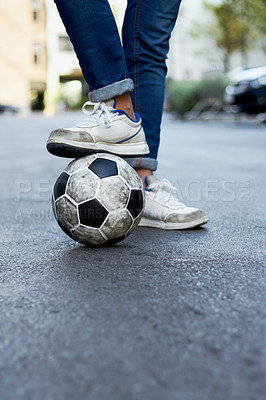 Buy stock photo Cropped image of a man's foot on a soccer ball in the street