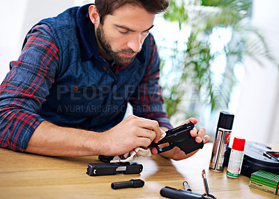 Buy stock photo A young man cleaning his gun