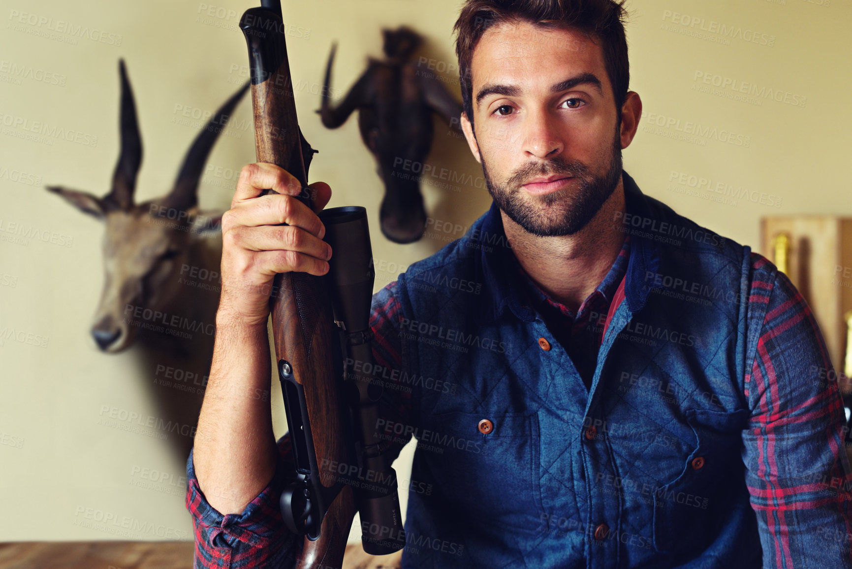 Buy stock photo Portrait of a hunter sitting in front of his trophies