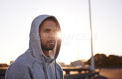 Buy stock photo A focused young sportsman wearing a hoodie and looking away