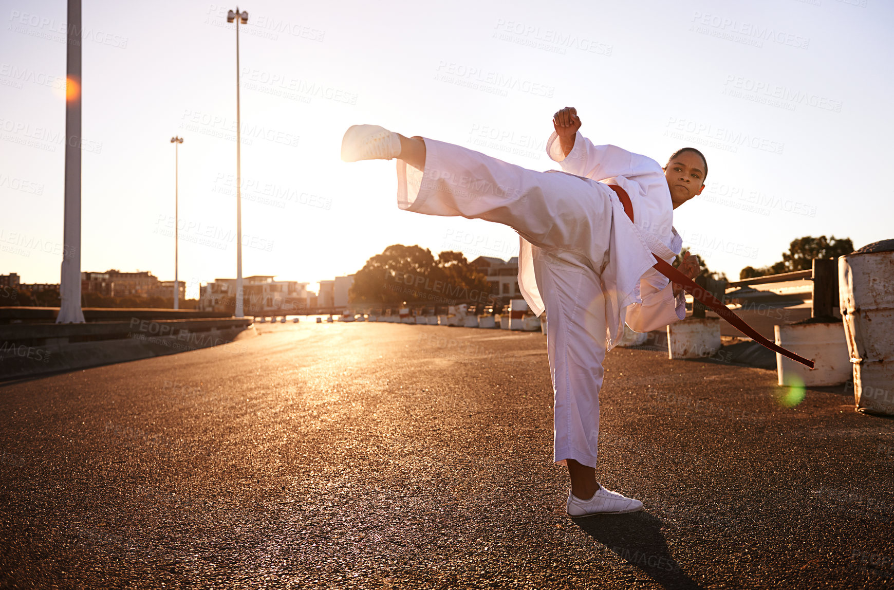 Buy stock photo A young woman in a gi practicing her kicks