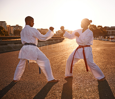 Buy stock photo People, karate and fighting with personal trainer for self defense, technique or style in city street. Man and woman fighter or athlete in fitness training, martial arts or kick boxing in urban town