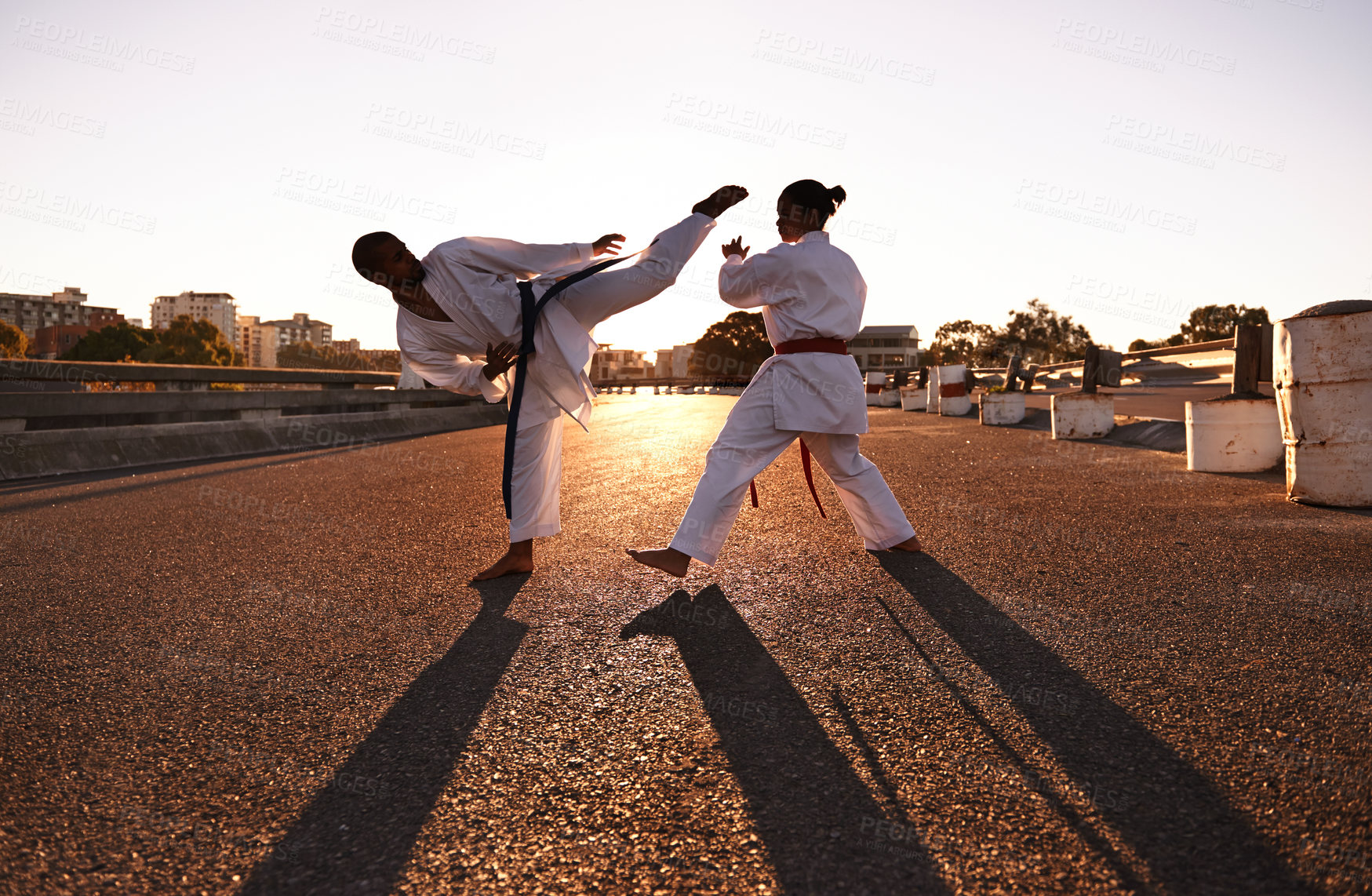 Buy stock photo People, karate and fitness with personal trainer in city street for self defense, fighting technique or style. Man and woman fighter or athlete in training, martial arts or kick boxing in urban town
