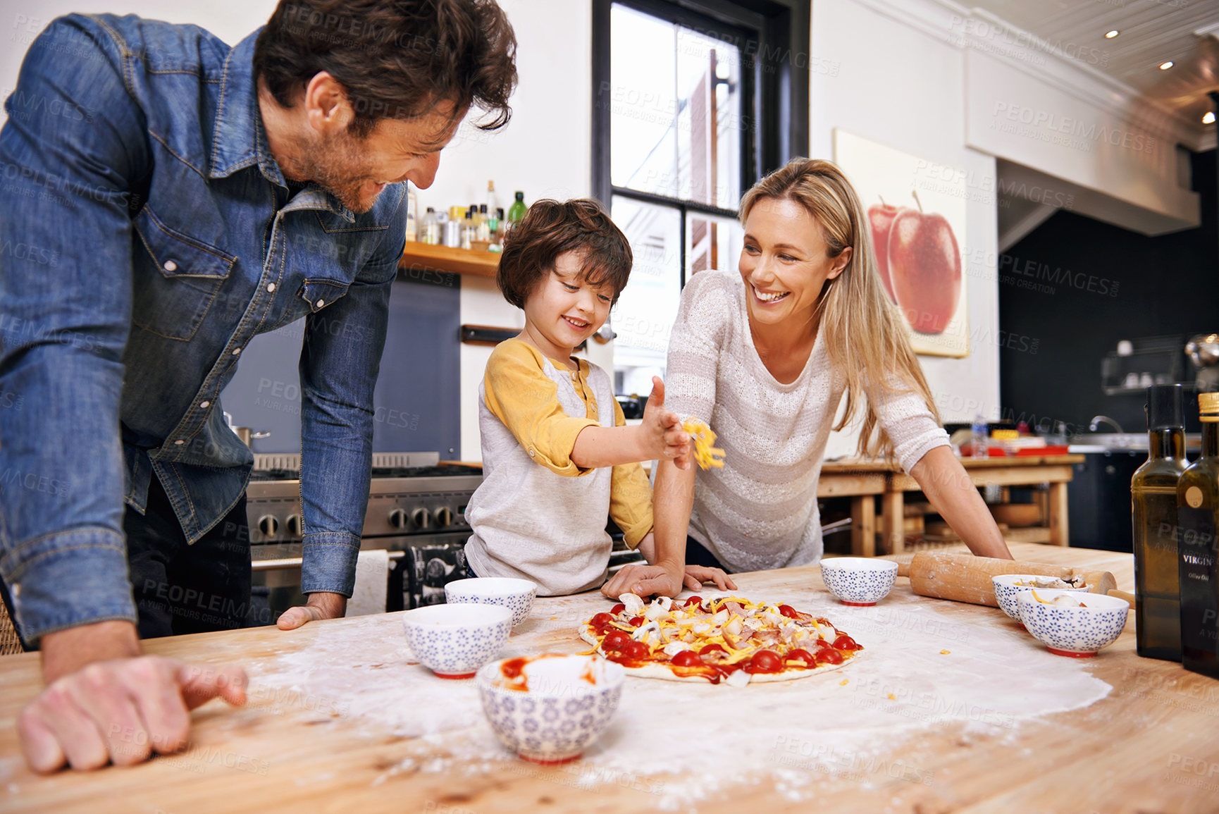 Buy stock photo A family making pizza together at home
