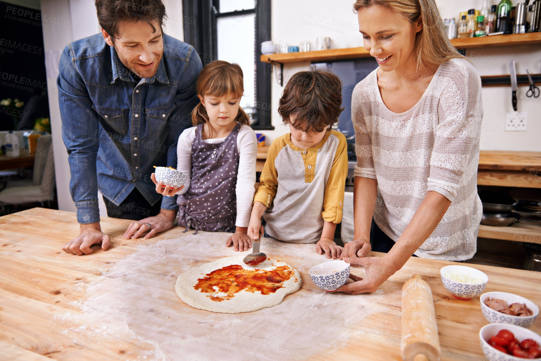 Buy stock photo Happy, family and cooking pizza in kitchen together, counter with pastry and sauce for Italian food for summer. Smile, parents and children helping or support in preparation process in home for fun
