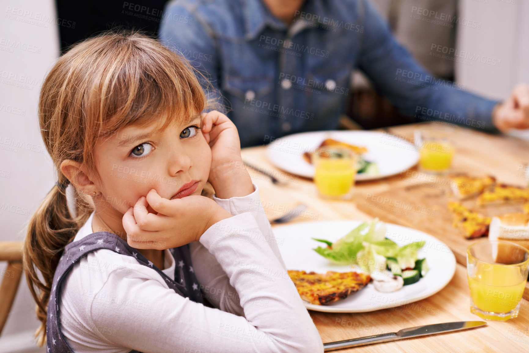 Buy stock photo A little girl sitting at the dinner table with a sulky look