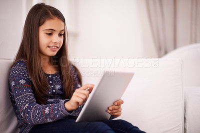 Buy stock photo Relax, home or girl with tablet for elearning, playing games or streaming videos on a movie website. Education, online or female child with technology to download on app or reading ebook on couch