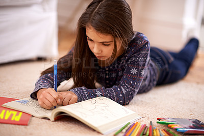Buy stock photo Girl, coloring book and drawing on floor for art in home with learning, development or lying in lounge. Kid, pencil and education for studying, creativity or relax on carpet at family house in Madrid