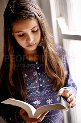 Buy stock photo Girl, child and book for reading in home with thinking, learning and language by window for studying. Kid, literacy and ideas with story, novel and fantasy with education in family house in Madrid