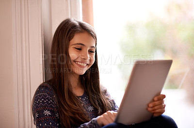 Buy stock photo Girl, child and tablet, happy with technology and relax with ebook for reading and social media at home. Website, cartoon or storytelling app with internet, browse and digital platform for gaming