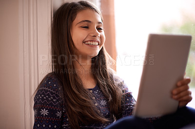 Buy stock photo Girl, kid and tablet, happy with technology and relax with ebook for reading and social media at home. Elearning, cartoon or storytelling app with internet, browsing and digital platform for gaming