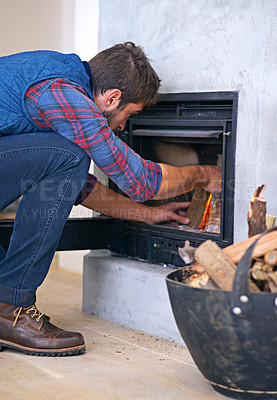 Buy stock photo Fireplace, wood and man ignite fire for heat, warmth and light in winter in home. Flame, burning and person with firewood or logs for comfortable, cozy and relax for thermal heating in living room
