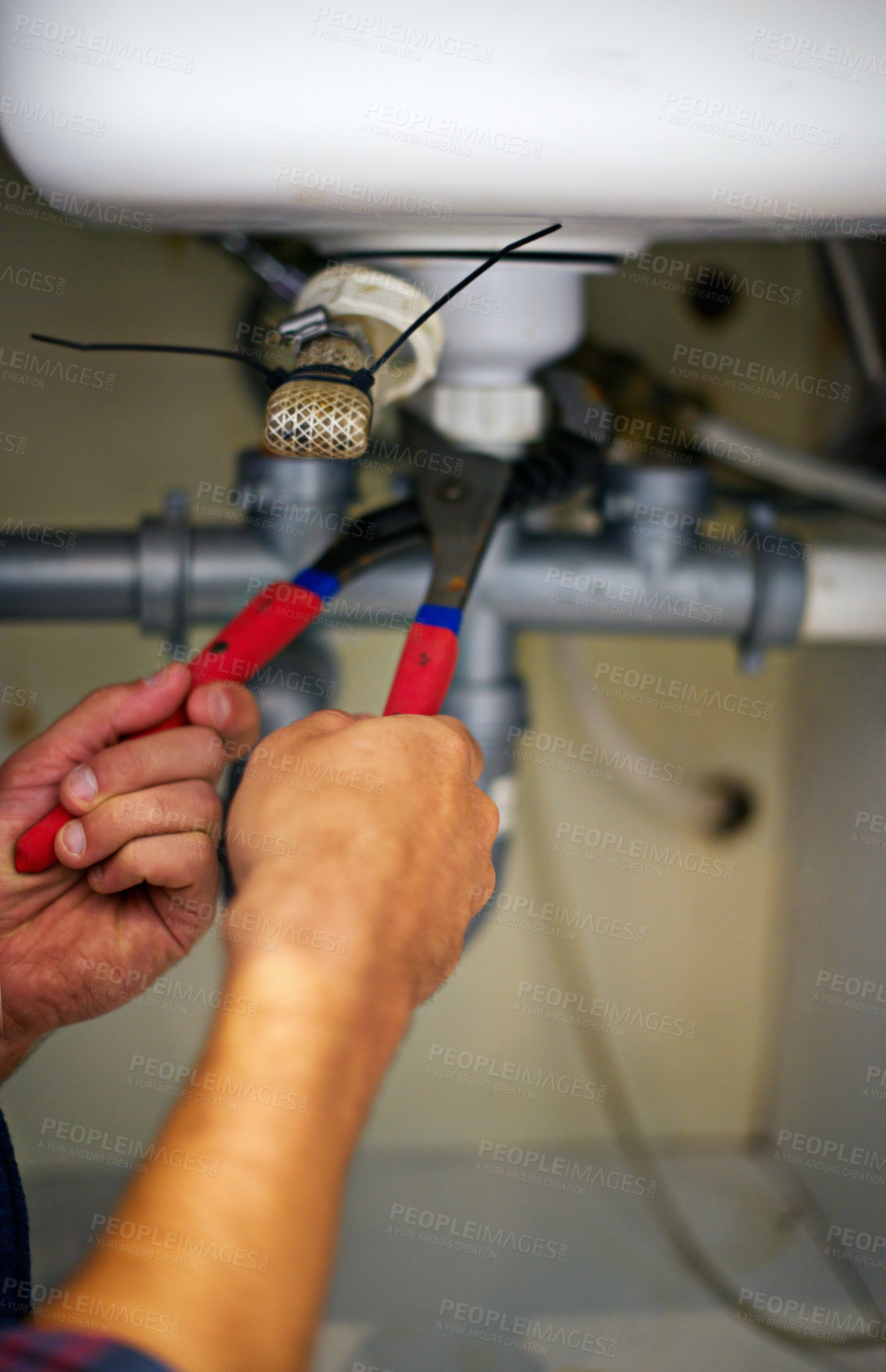 Buy stock photo Closeup, hands and plumber with wrench on pipe for repair, service or fix in home maintenance or indoor leak. Person, handyman or plumbing professional with tool for water or sink damage at the house