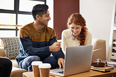 Buy stock photo Cropped shot of a young couple sitting on their laptop at a coffee shop