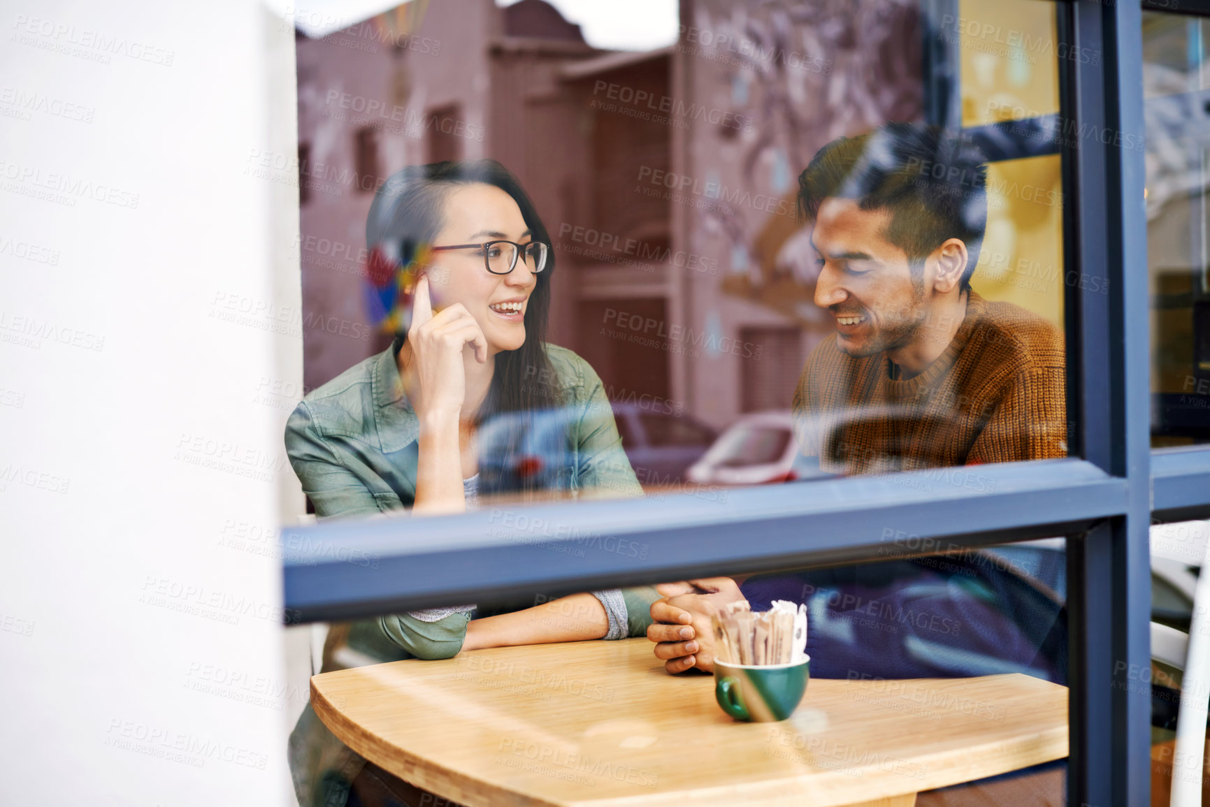 Buy stock photo Happy couple, relax and enjoying cafe with date for conversation, bonding or romance at indoor restaurant. Man and woman with smile by window at coffee shop for social, talking or chatting at table