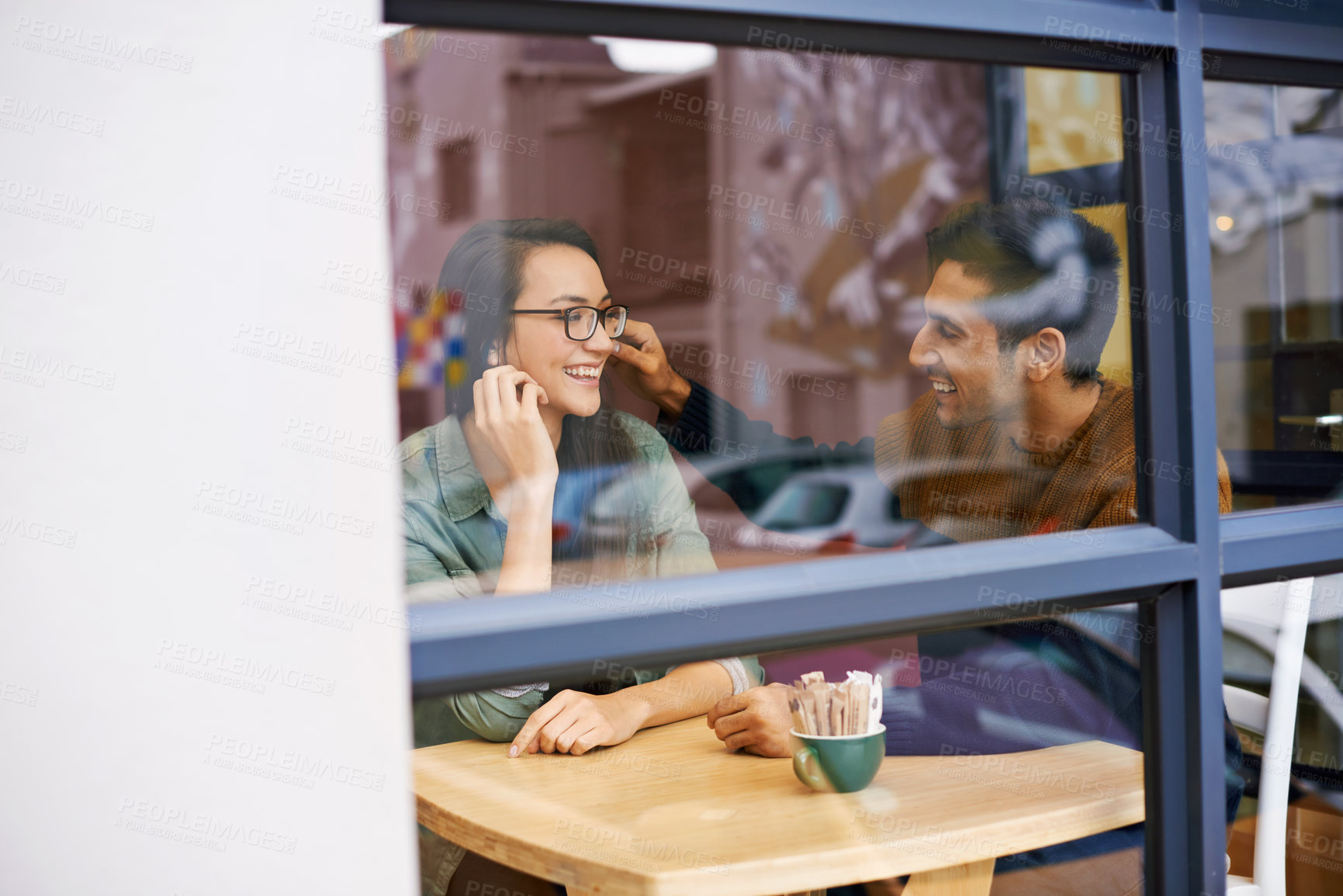 Buy stock photo Happy couple, bonding and relax with date at cafe for conversation or enjoying romance at indoor restaurant. Man and woman with smile by window at coffee shop for social, chatting or talk on mockup