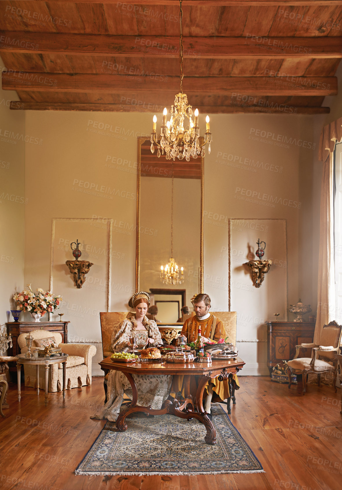 Buy stock photo Noble, couple and luxury with food, dinner and renaissance home or house and dining table. King, queen and palace with royal feast, rich meal and wealthy monarch or ruler with tudor era supper