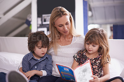 Buy stock photo Reading, mother and children on couch with book for bonding, teaching and learning together in home. Woman, son and daughter relax on sofa with storytelling, smile and happy family in living room
