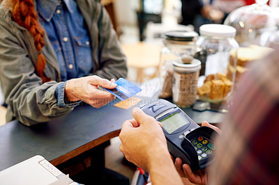Buy stock photo Shot of a customer paying for their order with a credit card machine in a cafe