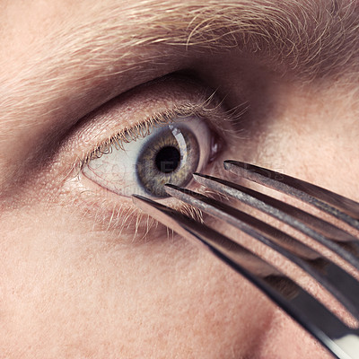 Buy stock photo A cropped view of a fork pointed at an eye