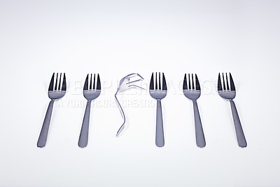 Buy stock photo A broken fork lying in a row of forks