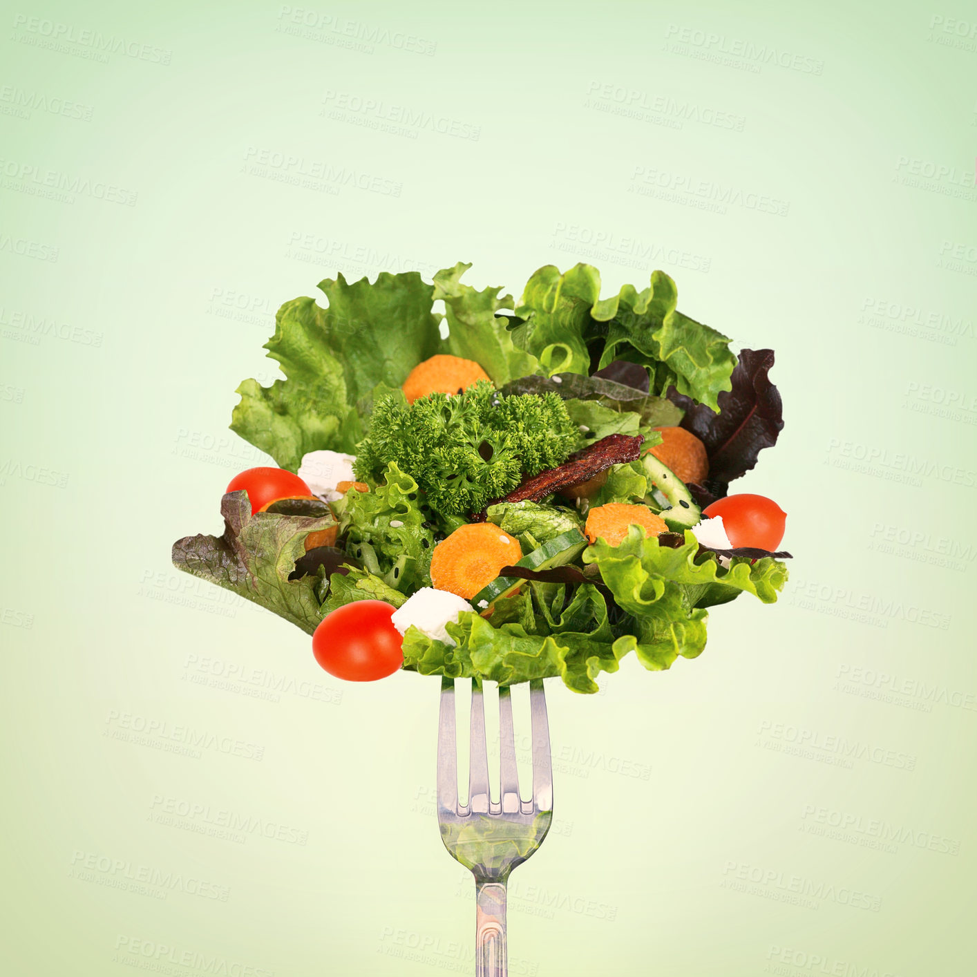 Buy stock photo A forkful of salad against a green background