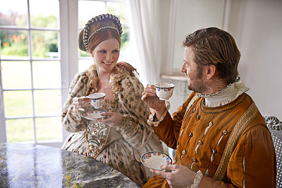 Buy stock photo King, queen and couple with tea in castle, smile and conversation in vintage clothes with luxury at breakfast. Woman, man and drink together in morning with Victorian fashion at regal palace in UK