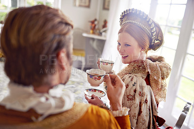 Buy stock photo Royal man, woman and tea in castle with conversation, smile and vintage clothes with style in home. King, queen and couple with drink together in morning with Victorian fashion at regal palace in UK