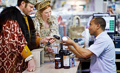 Buy stock photo A king and queen buying groceries and paying at the cashier
