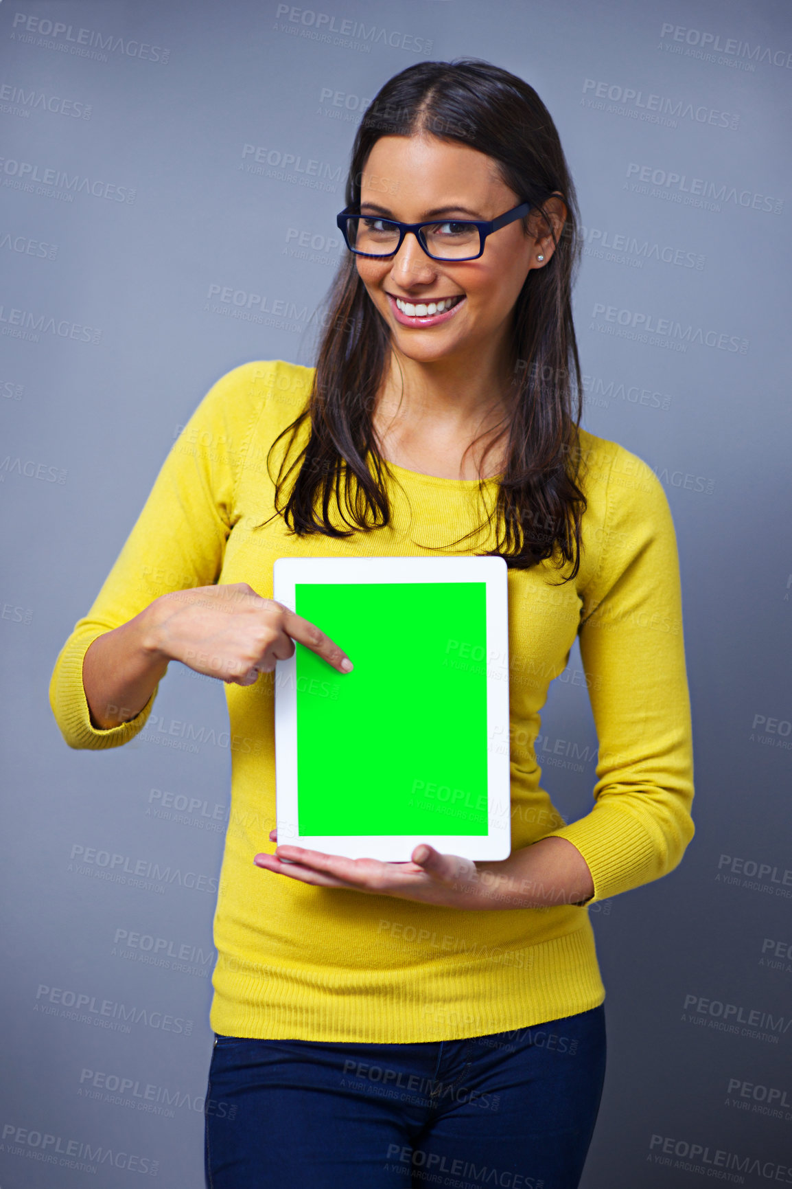 Buy stock photo Woman, tablet and green screen for studio portrait with pointing, presentation or show ux by grey background. Student, person and digital touchscreen with chromakey for mockup space, app or promotion