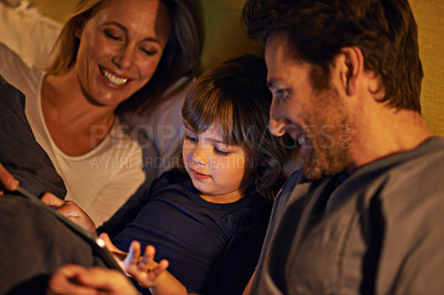 Buy stock photo Night, parents or kid with tablet for streaming, playing games or watching videos on movie website in home. Social media, child or happy mom with dad or technology to download on ebook online in bed