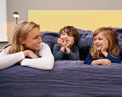 Buy stock photo Home, mother and kids in bed with love, support and bonding together with a smile. Happy, family and children with mom in the morning in the bedroom relax with youth in a house with parenting