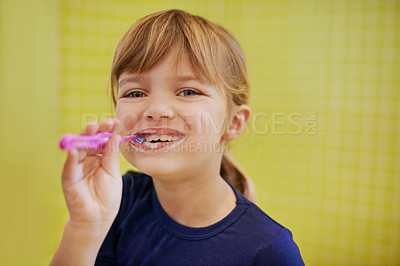Buy stock photo Girl, portrait or child in studio brushing teeth with smile for development isolated on yellow background. Morning, learn or kid cleaning mouth with toothbrush for dental or oral health for wellness