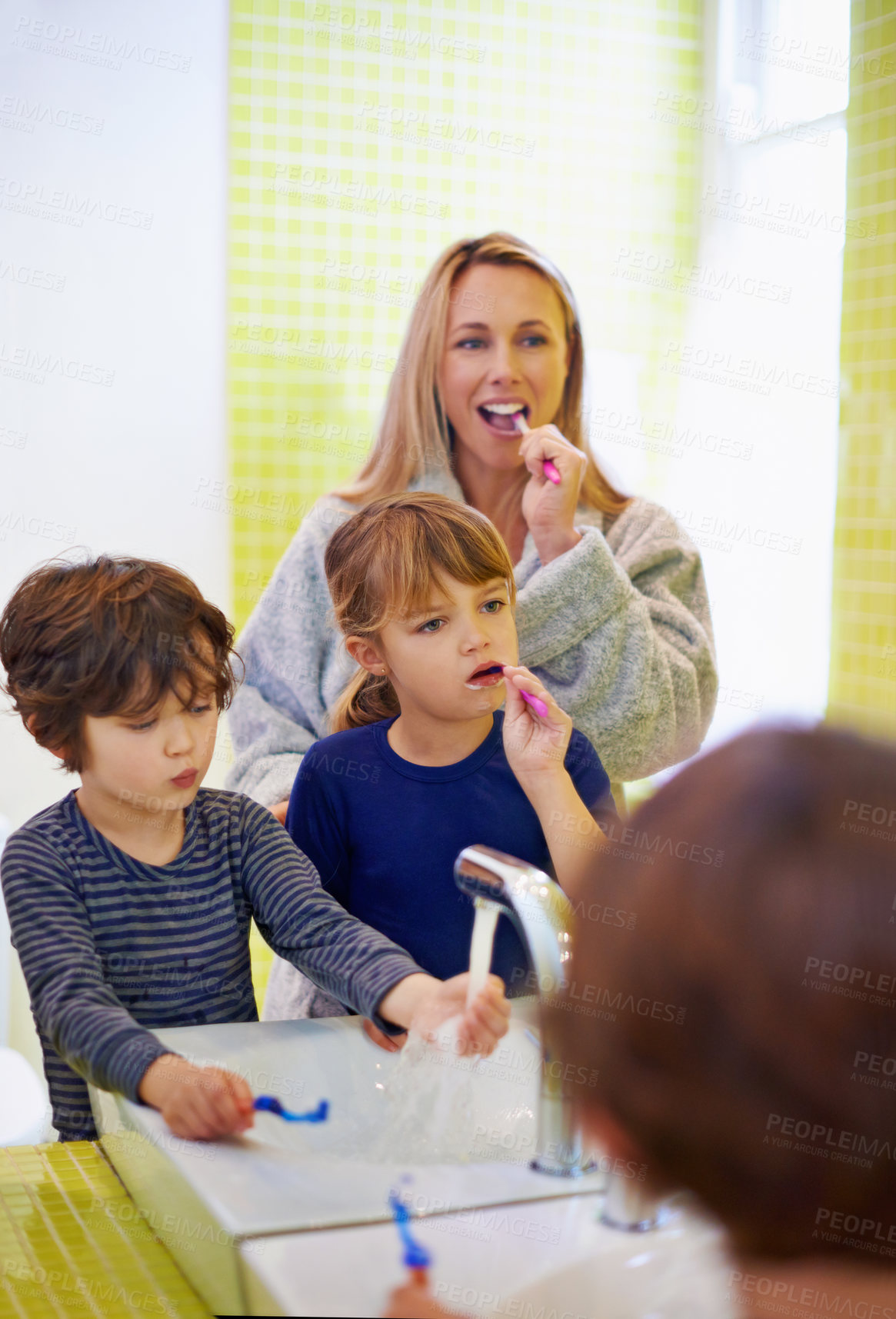 Buy stock photo Shot of a young family brushing their teeth in the bathroom