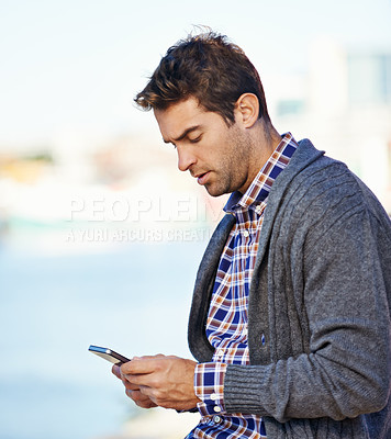 Buy stock photo Man, phone and texting at harbor on mobile network by sea for typing, contact or reading outdoor. Person, smartphone and click at urban port in city for notification, app or social media in Cape Town