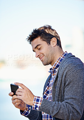 Buy stock photo Man, cellphone and texting at harbor on mobile network by sea for typing, smile and reading outdoor. Person, phone and click at urban port in city for notification, app or social media in Cape Town
