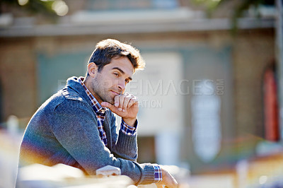 Buy stock photo Man, think and sitting in city for idea and trip for travel or relax in urban or outdoor on blurred background. Young person and looking for view, comfort and break for wonder and pensive on mockup
