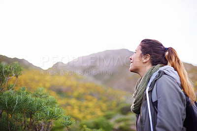 Buy stock photo Woman, smile and hiking for adventure in nature with mountain for walking outdoor for exercise. Young person with backpack and looking for view in landscape with bush and plants in cold season