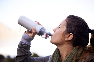 Buy stock photo Woman, hiking and outdoor to drink with bottle, water and hydration for health, fitness and adventure. Girl, person and trekking in bush, mountains and rocks for electrolytes on journey in Cape Town