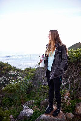 Buy stock photo Woman, hiking and outdoor in nature with bottle for water with fitness, hydration or vision on adventure. Girl, person and trekking in bush, mountains and rocks for journey on vacation in Cape Town