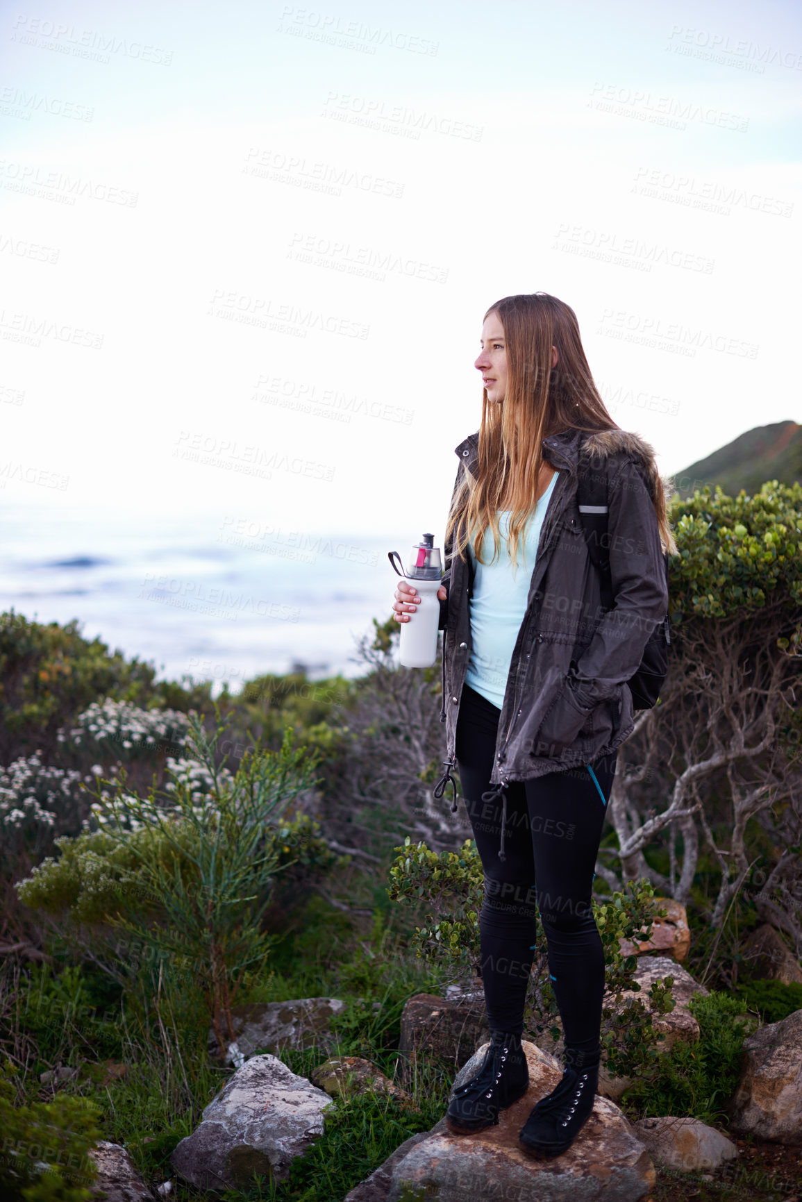 Buy stock photo Woman, hiking and outdoor in nature with bottle for water with fitness, hydration or vision on adventure. Girl, person and trekking in bush, mountains and rocks for journey on vacation in Cape Town