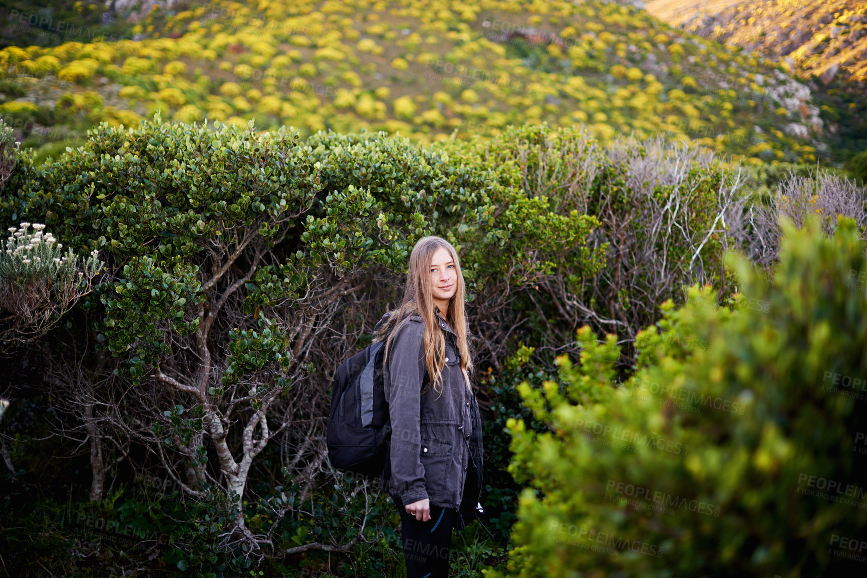 Buy stock photo Landscape, portrait and woman hiking with smile, vacation and adventure with backpack for journey. Adult, girl and female person in holiday for winter in nature of Cape Town for plants in bush