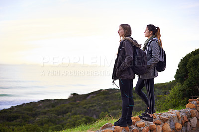 Buy stock photo Outdoor, hiking and friends in nature with backpack, sightseeing and standing to relax  on rock. Women, girl and female person on vacation for break or holiday in peace of forest and journey