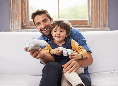 Buy stock photo A handsome father and his cute son playing a video game together
