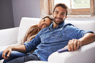 Buy stock photo Happy couple, watching tv on sofa and relax together in living room with streaming service, trust and hug for bonding. Man, woman with Netflix and chill in portrait, partner and remote for television
