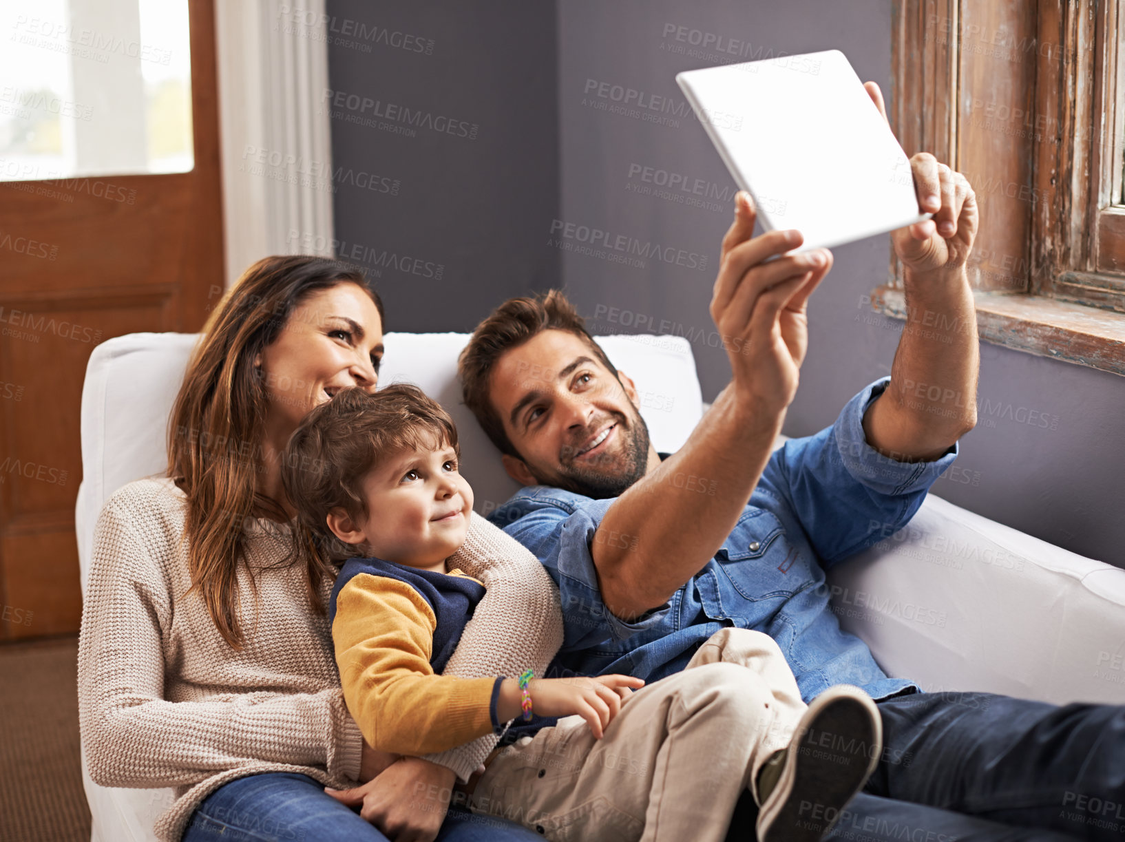 Buy stock photo Shot of a happy family using a digital tablet together