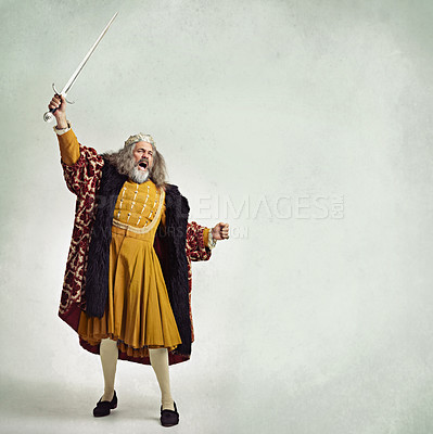 Buy stock photo Studio shot of a richly garbed king brandishing a sword