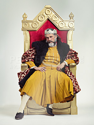 Buy stock photo Studio shot of a richly garbed king sitting on a throne