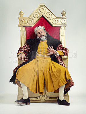 Buy stock photo King, royalty and bored man on throne in studio isolated on gray background. Monarch, medieval royal and annoyed senior male, leader or frustrated ruler, looking at hand and sitting on golden seat.