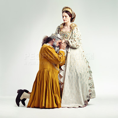 Buy stock photo Studio shot of a king kneeling and kissing his queen's hand